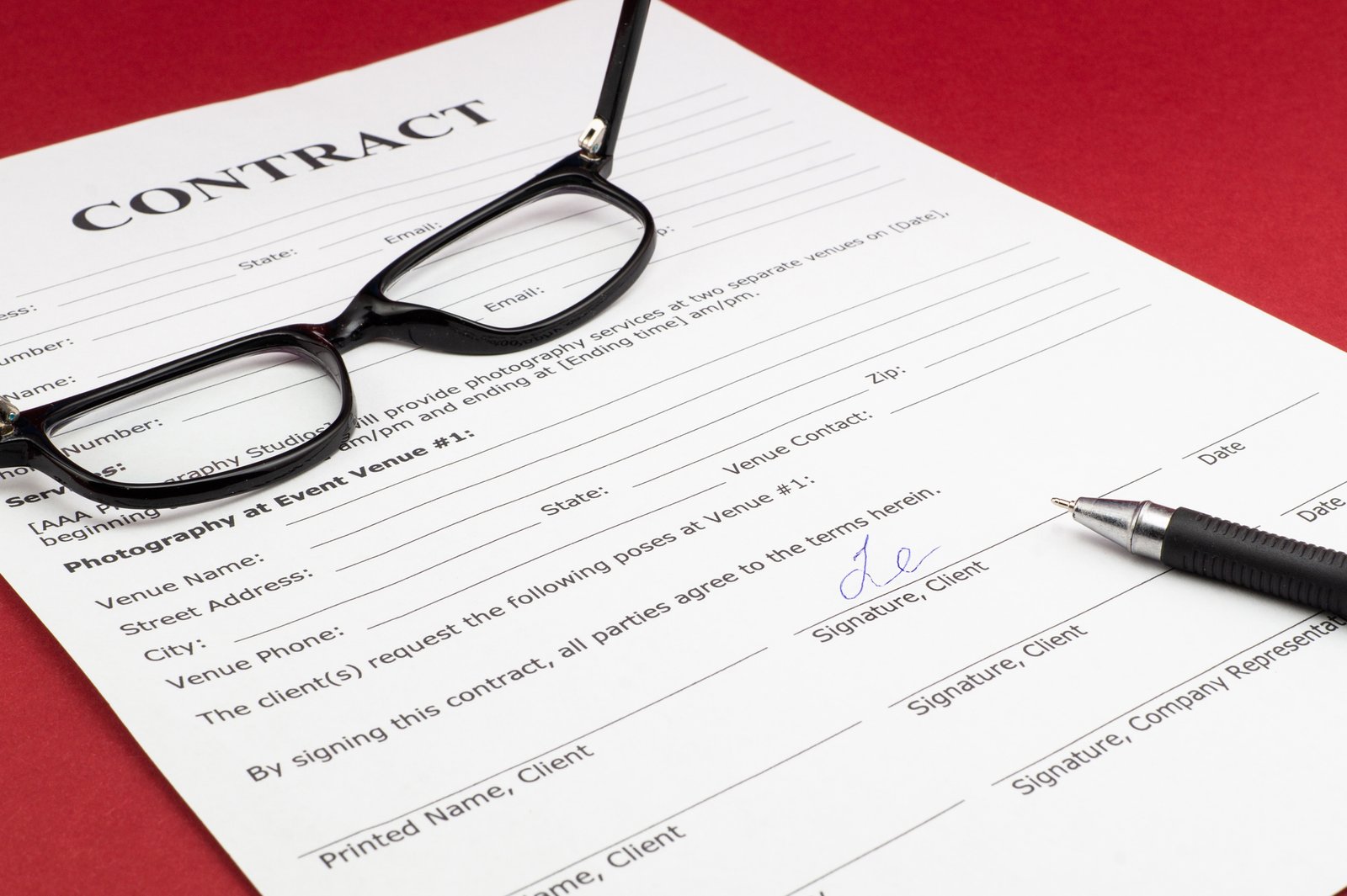 Contract document and glasses illustrating questions to ask a bus rental company